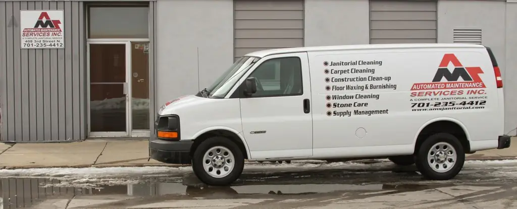 AMS van parked in front of the Automated Maintenance Services shopfront and sign